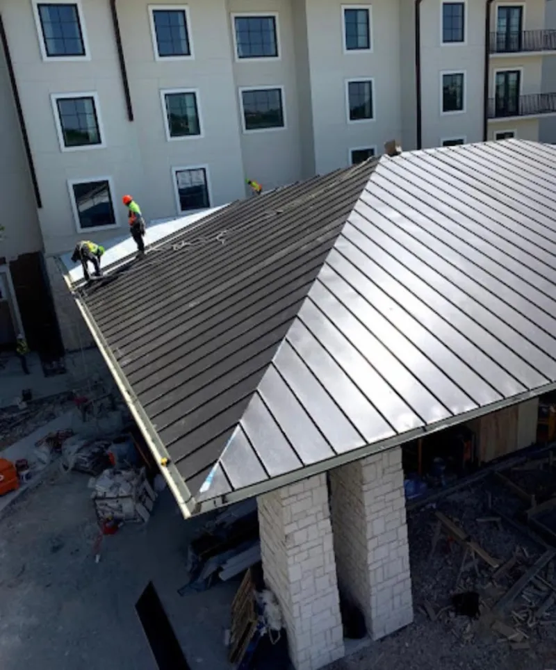 Crew installing standing seam metal roof panels on a commercial project in Los Altos